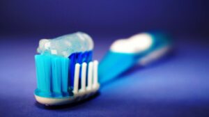 Toothbrush and toothpaste on blue background
